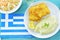 Greek flag and meal of traditional Greek dish of bread crumbed cod fishÂ  and garlic dip, known as skordalia, glass of white wine